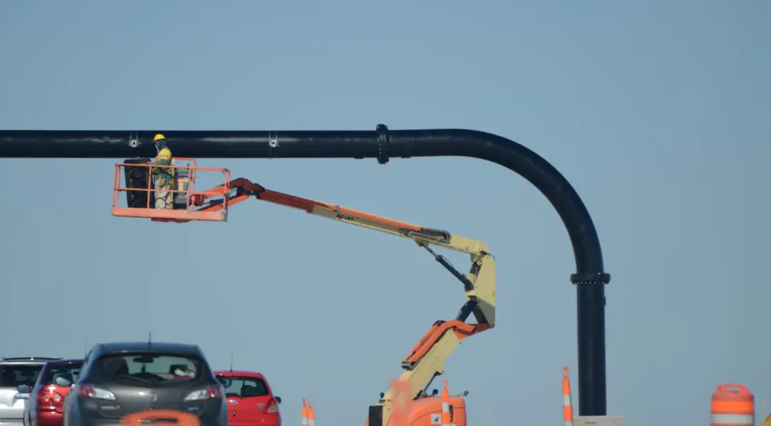 A crane is being used to lift pipes.