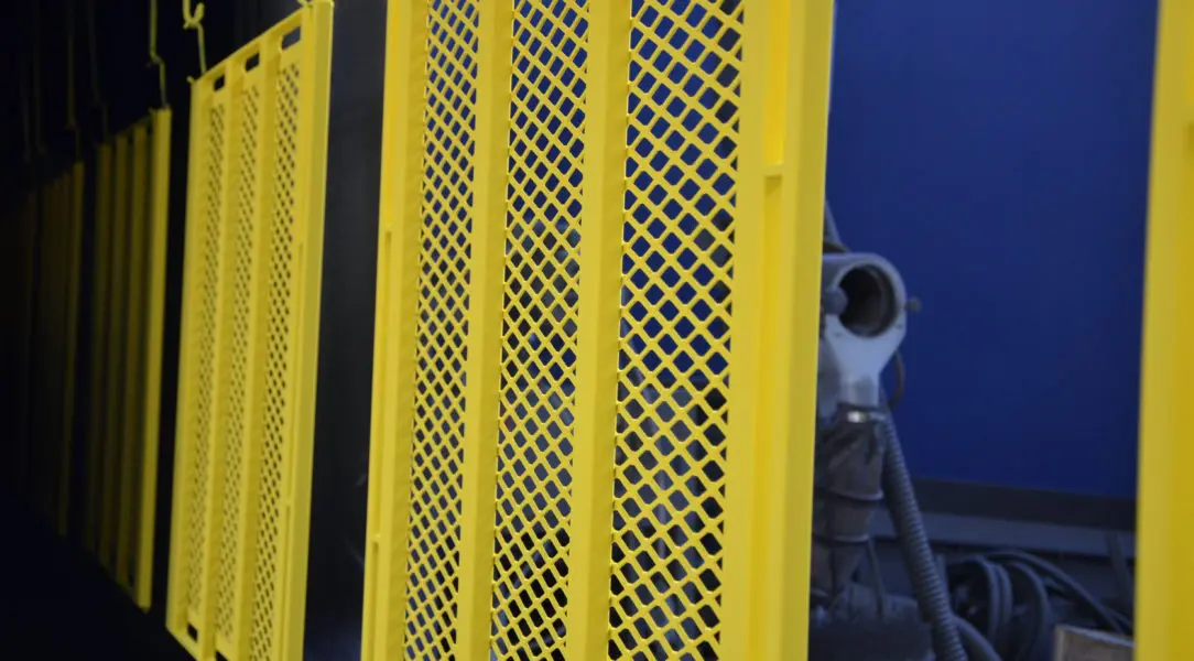 A yellow fence with a blue wall in the background.