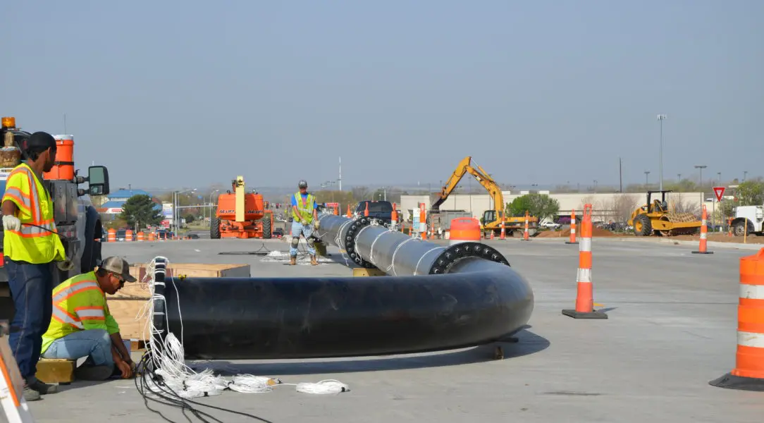 A large pipe laying on top of concrete.