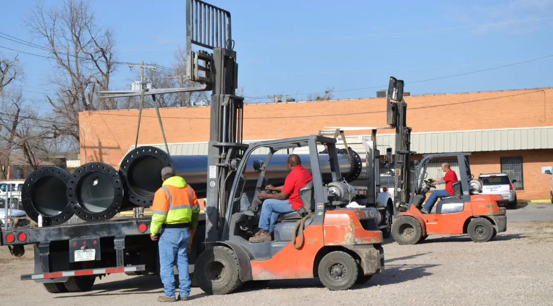 A forklift is parked next to other vehicles.